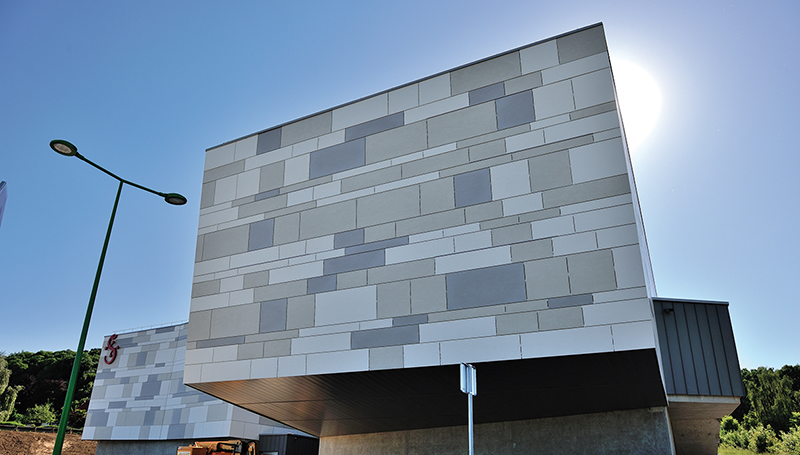 Panneaux en ciment composite utilisés pour la façade d'un bâtiment gris foncé, gris clair, bleu